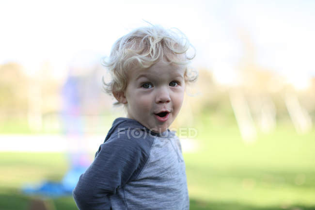 Портрет здивованого блондинки маленького хлопчика на відкритому повітрі — стокове фото