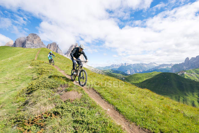 Мужчина и женщина катаются на горных велосипедах по тропе, Доломиты, Италия — стоковое фото