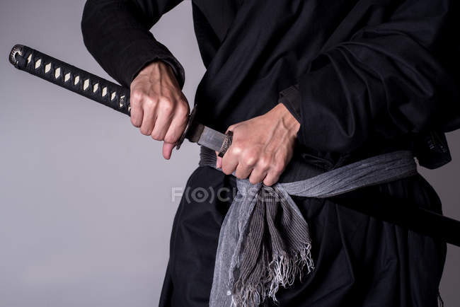 Bild des Mannes mit Katana-Schwert vor grauem Hintergrund — Stockfoto