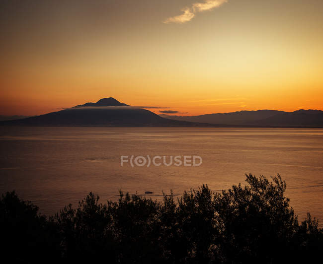 Vista panorámica de la puesta de sol sobre el Vesubio, Sorrento, Campania, Italia - foto de stock