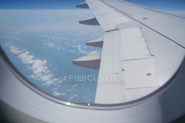 Крыло самолета видно через окно в полете — стоковое фото