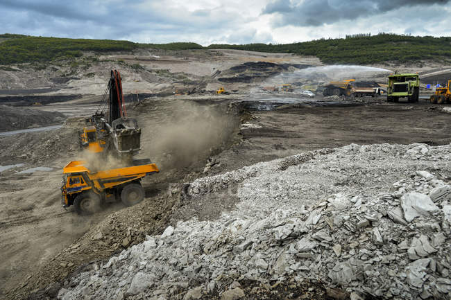 Вантажівка розкопує ґрунт на шахті в похмурий день — стокове фото