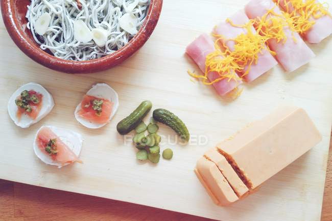 Appetizers cheese and meat on chopping board — Stock Photo