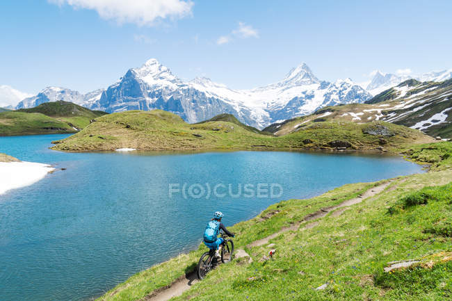 Mulher mountain bike em alpes suíços, Grindelwald, Suíça — Fotografia de Stock