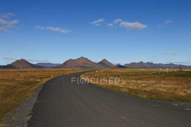 Vue panoramique de la route vide au-delà des montagnes, Islande — Photo de stock