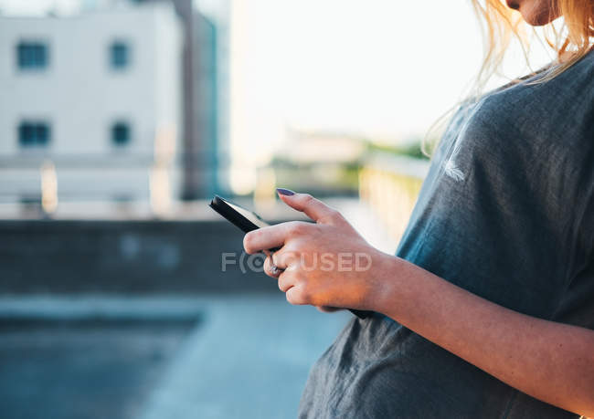 Primer plano de la Mujer de pie en la calle y utilizando una tableta digital - foto de stock