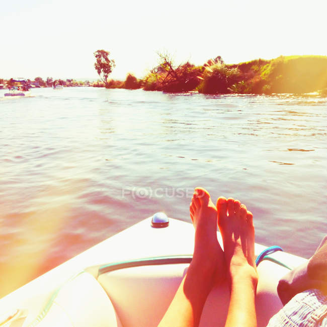 Geschnittenes Bild einer Frau, die sich auf einem Boot am Fluss entspannt — Stockfoto