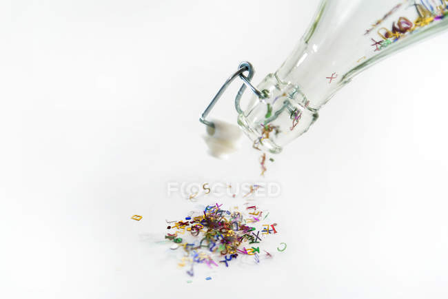 Letras mayúsculas multicolores saliendo de una botella - foto de stock