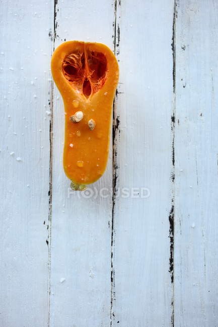 Half a Butternut squash on white wooden table — Stock Photo