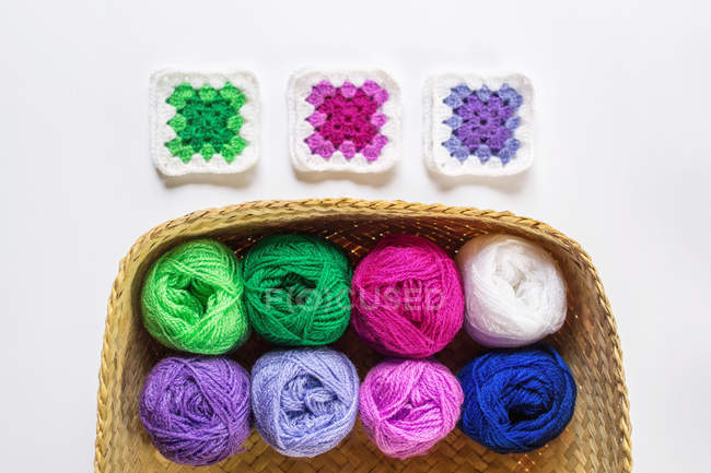 Top view of crocheted doilies and yarn in basket — Stock Photo