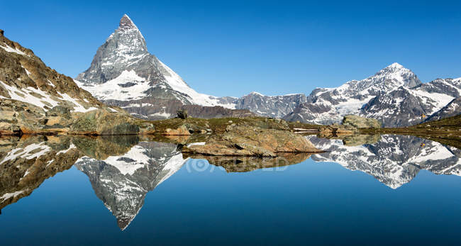 Vista panorámica de Matterhorn reflejada en el lago Riffelsee, Suiza - foto de stock