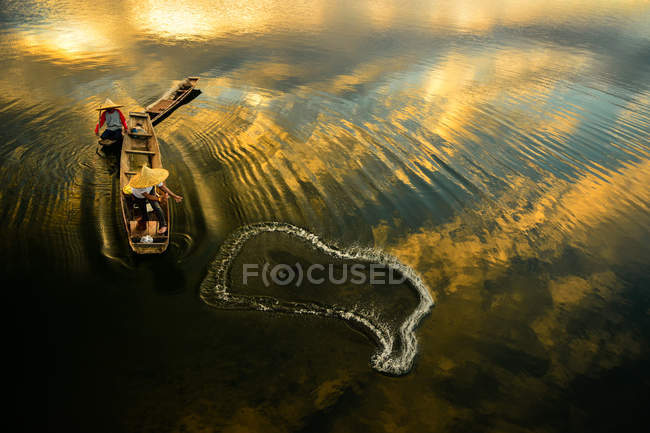 Deux pêcheurs jettent un filet dans la rivière au lever du soleil, Thaïlande — Photo de stock