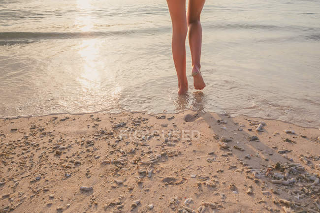 Imagem cortada de pernas femininas andando na praia — Fotografia de Stock