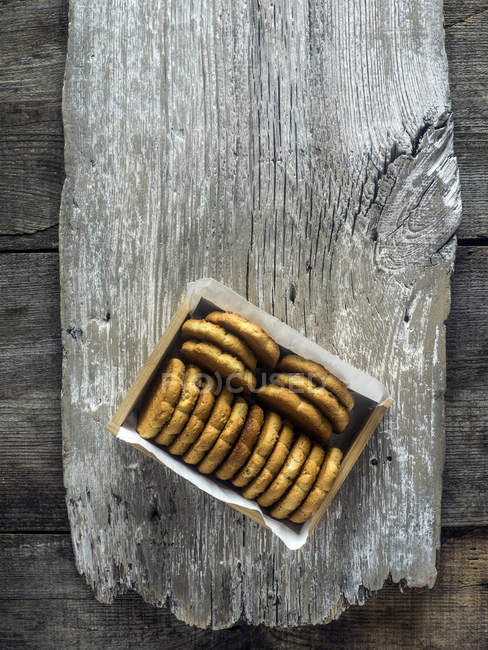 Box of corn biscuits on wooden plank, top view — Stock Photo