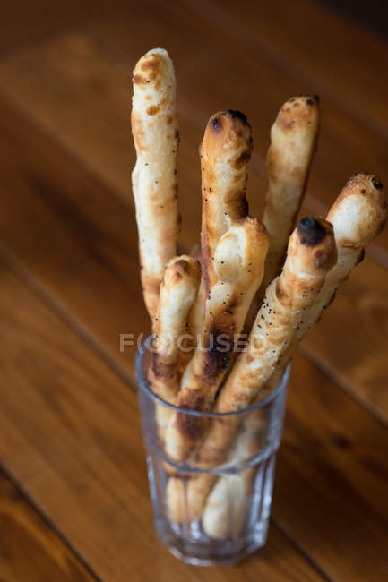 Хлебные палочки в стекле над деревянным столом — стоковое фото
