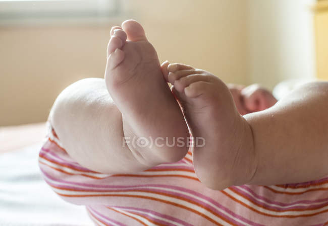 Imagen recortada de pies de bebé en la cama - foto de stock