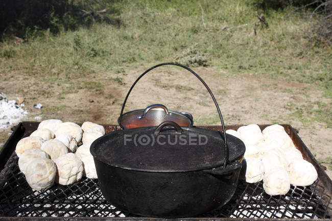 Hornear pan y cocinar guiso en la barbacoa - foto de stock