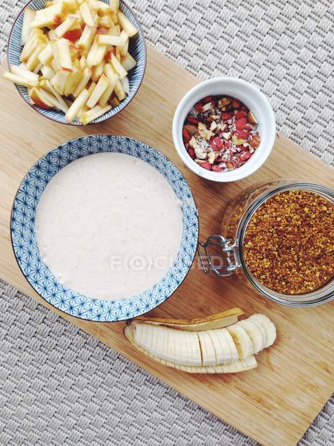 Raw oat porridge and toppings over kitchen table — Stock Photo