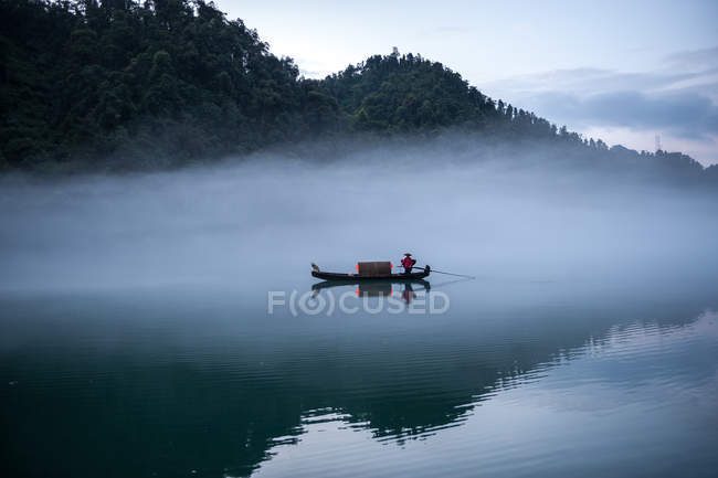 Hombre de vela Barco tradicional en el río Dong, Ganzhou, China - foto de stock