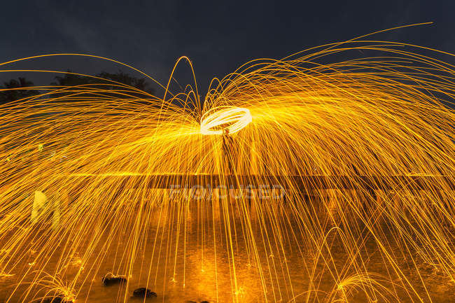 Man fire dancing with steel wool — Stock Photo