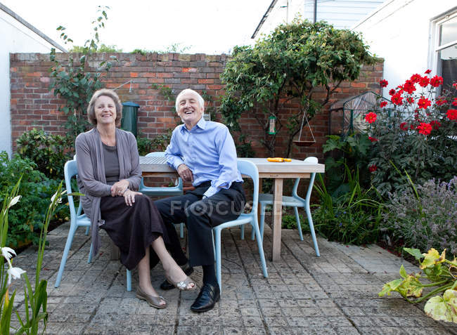 Anziano coppia caucasica seduta insieme a tavola nel patio — Foto stock