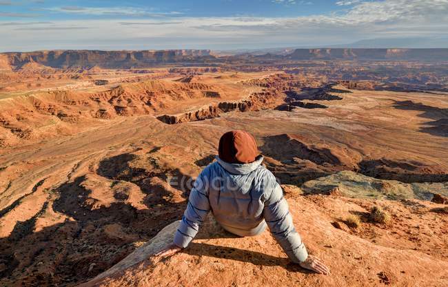 EUA, Utah, Parque Nacional de Canyonlands, Caminhante sentado e olhando para Buck Canyon — Fotografia de Stock