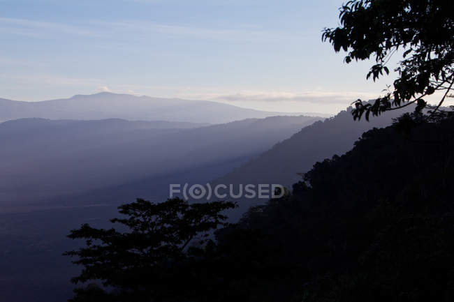 Vista panorâmica dos raios de sol matinais iluminando a cratera Ngorongoro, na Tanzânia — Fotografia de Stock