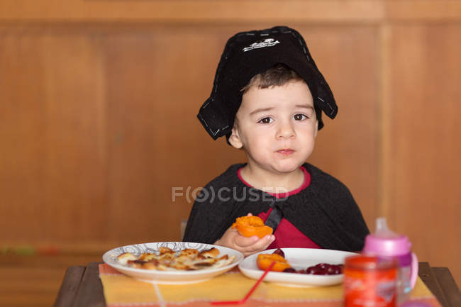 Garçon manger petit déjeuner habillé en pirate — Photo de stock
