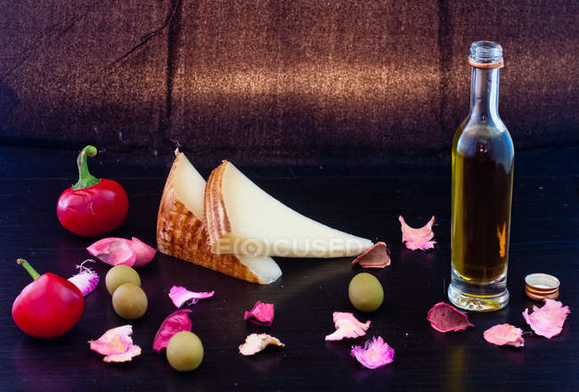 Chili, queso, aceitunas y aceite de oliva, fondo oscuro - foto de stock