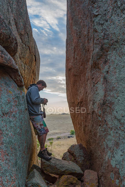 Man checking camera between rock formations, Murphys Haystacks, South Australia, Australia — Stock Photo
