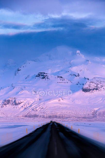 Vista panorâmica da estrada reta vazia na neve paisagem rural coberta, Islândia — Fotografia de Stock