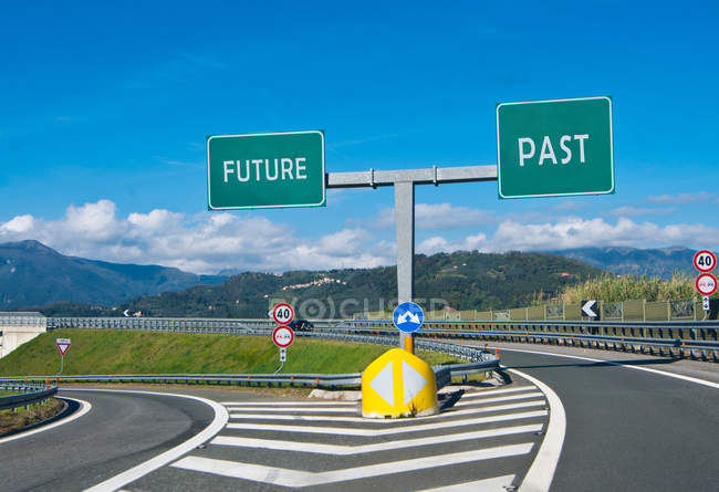 Дорога з майбутніми та минулими дорожніми знаками на стику — стокове фото