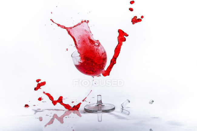 Copo de líquido vermelho em copo de vinho quebrado — Fotografia de Stock