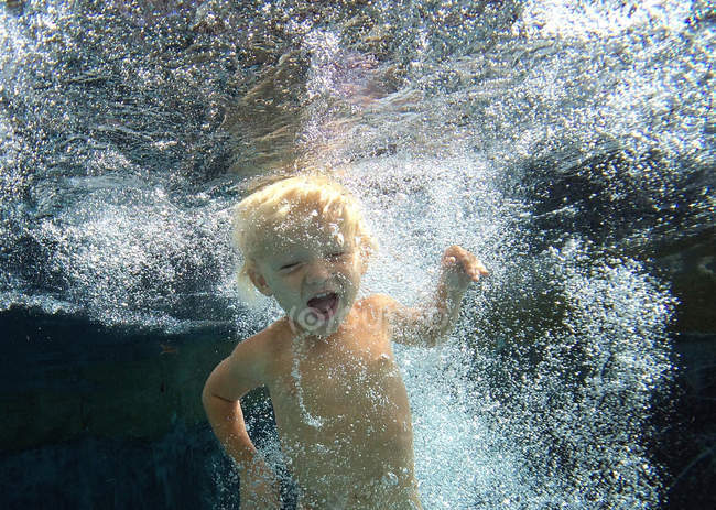 Menino nadando debaixo d 'água na piscina — Fotografia de Stock