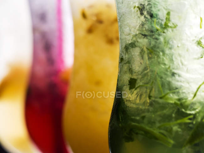 Primer plano de cuatro vasos de limonada de frutas - foto de stock