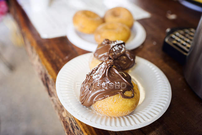 Cinnamon donuts covered in chocolate spread on a plates — Stock Photo