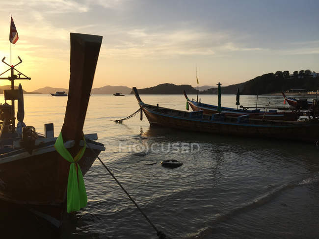 Scenic view of boats moored at the beach at sunset, Phuket, Thailand — Stock Photo