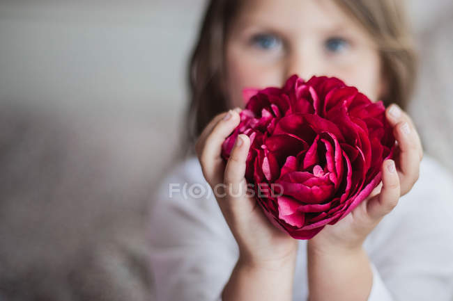 Gros plan de Fille tenant une fleur rouge — Photo de stock
