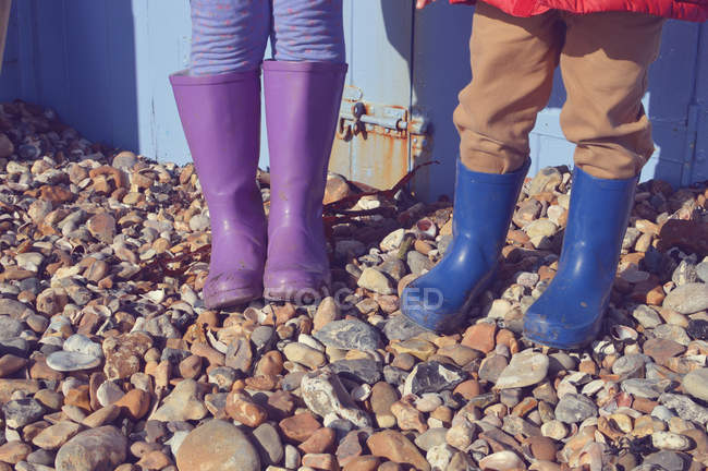 Immagine ritagliata di due bambini in wellies alla spiaggia — Foto stock