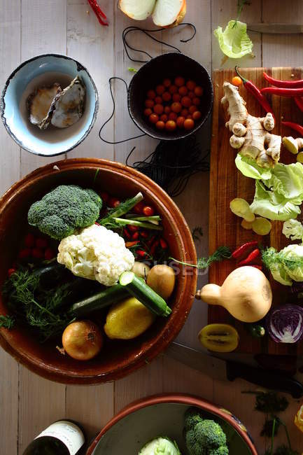 Свежие овощи и устрицы на кухонном столе, вид сверху — стоковое фото