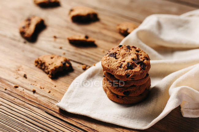 Pila di biscotti con gocce di cioccolato sul tavolo di legno — Foto stock