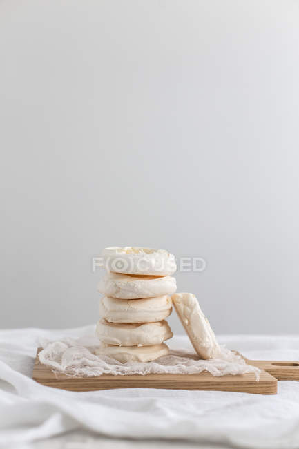 Stack of tasty meringues against white wall — Stock Photo
