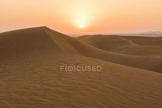 Salida del sol sobre dunas de arena del desierto, Dubai, Emiratos Árabes Unidos - foto de stock