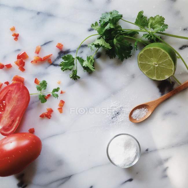Frische Limetten, Tomaten und Petersilie auf Marmortisch — Stockfoto