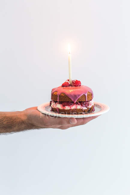 Мужская рука с тортом в честь дня рождения Виктории со свечой — стоковое фото