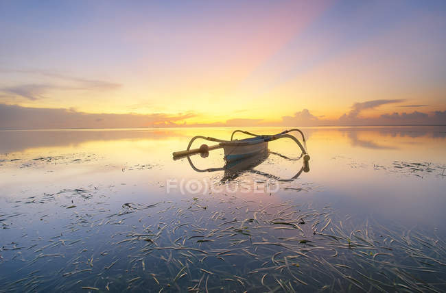 Scenic view of boat on Sanur Beach at sunset, Denpasar, Bali, Indonesia — Stock Photo