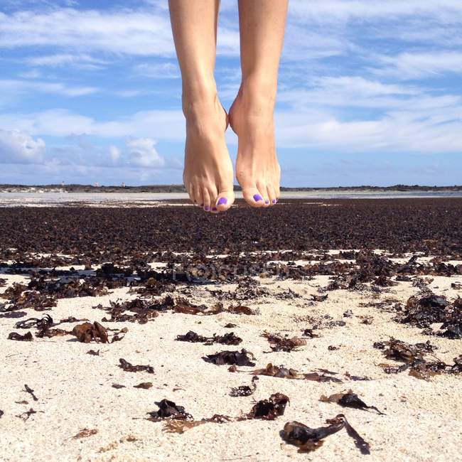 Cropped image of female feet in mid air — Stock Photo
