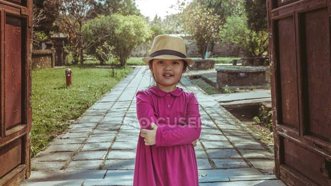 Girl wearing hat standing with arms crossed on path — Stock Photo