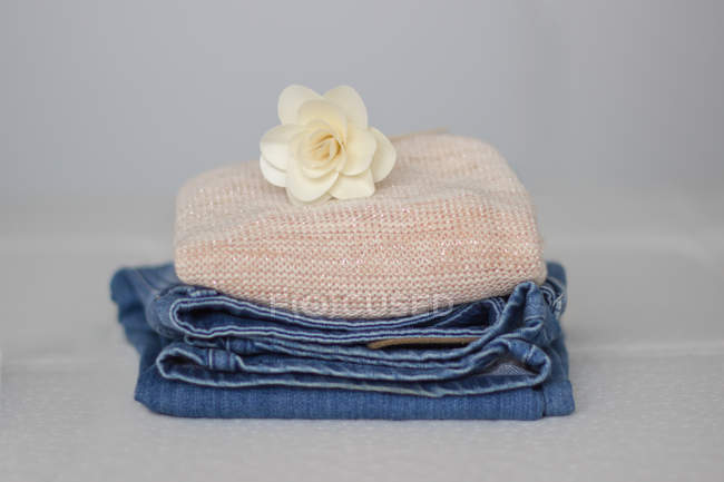 Closeup view of pile of clothes with a flower on top — Stock Photo