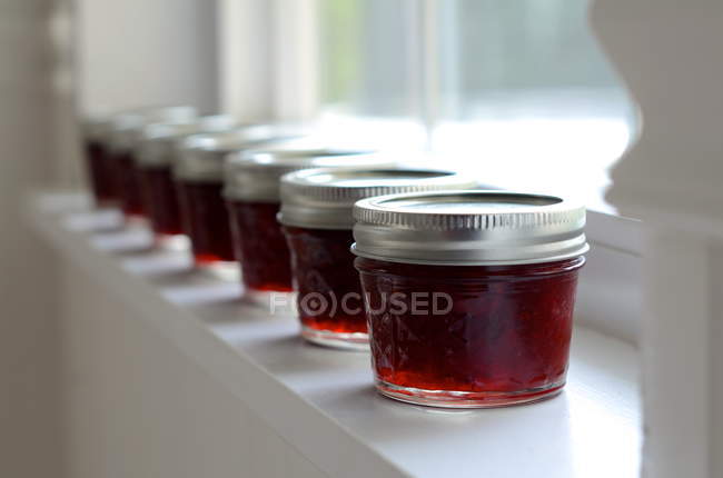 Reihe roter Marmeladengläser am Fenster — Stockfoto